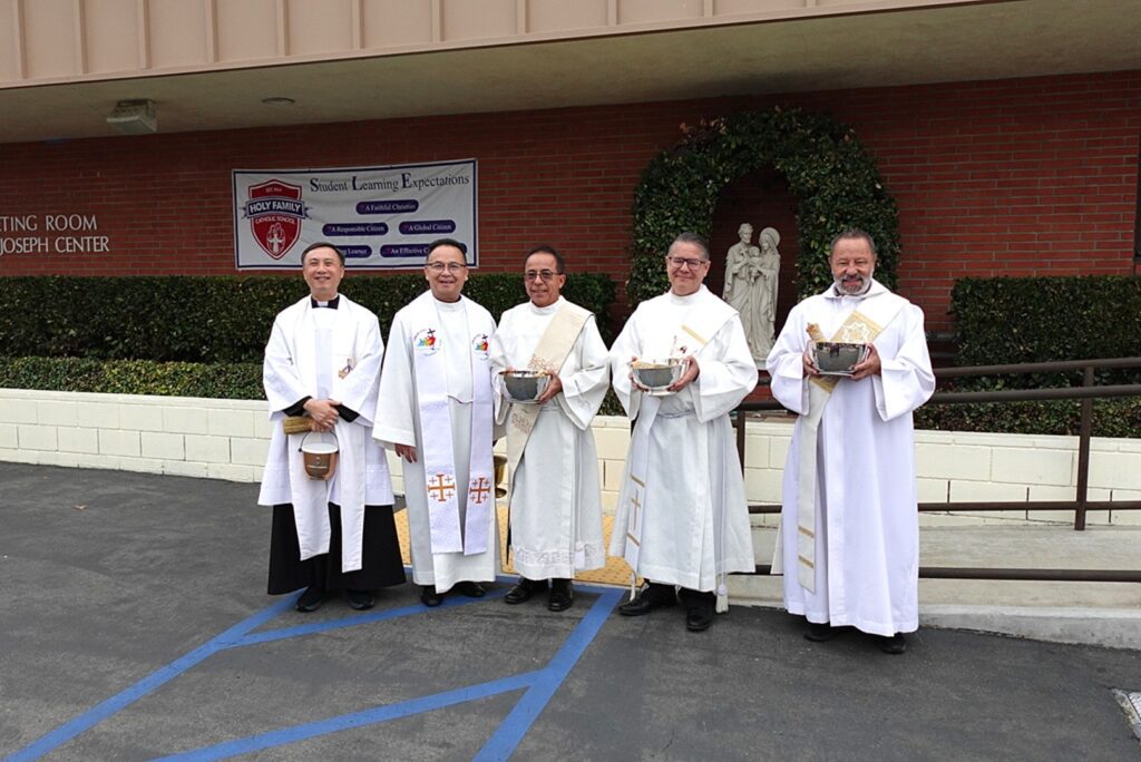 Priests and deacons attend the Blessing of the Animals event at Holy Family Catholic School