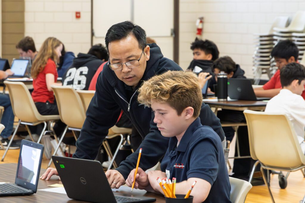 A student gets assistance from a teacher at the diocesan math competition at Holy Family School in Orange. 
